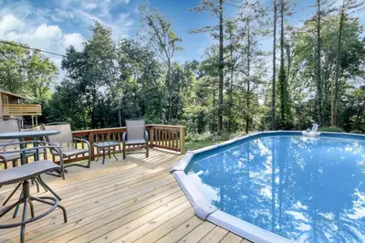 a deck with a pool and a table and chairs at Adventures at Aspen Way in Rockbridge