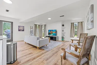 a living room with a white couch and chairs at Luxury on Lakeside