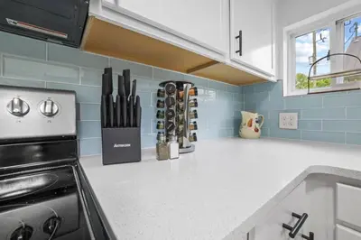 a kitchen with a white counter top with a stove at Luxury on Lakeside