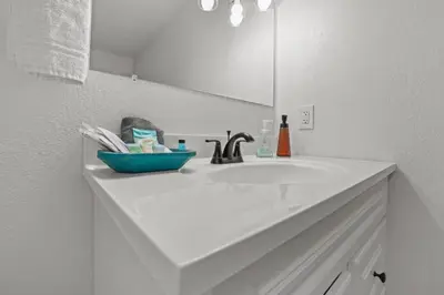 a white bathroom with a sink and a mirror at Luxury on Lakeside