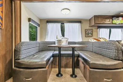 a dining area in an rv with a table and stool at Chestnut Camper in Lancaster