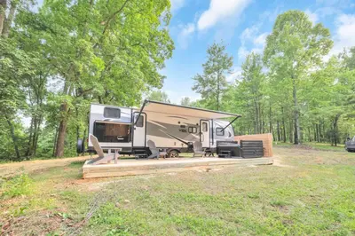 an rv parked in a field in a forest at Chestnut Camper in Lancaster