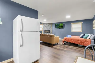 a living room with a white refrigerator and a couch at The Blue Spruce in Lancaster