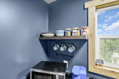 a kitchen with blue walls and a shelf with mugs at The Blue Spruce in Lancaster