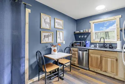 a kitchen with blue walls and a table and chairs at The Blue Spruce in Lancaster