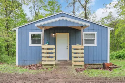 a blue tiny house with a white door at The Blue Spruce in Lancaster