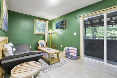 a living room with green walls and a couch and a table at The Evergreen Cabin in Lancaster