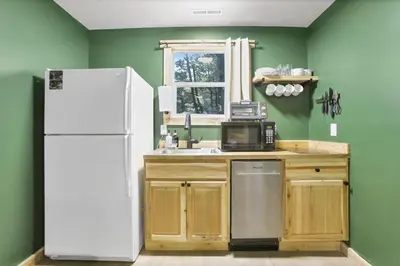 a kitchen with green walls and a white refrigerator at The Evergreen Cabin in Lancaster