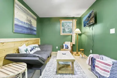 a living room with green walls and a couch and a table at The Evergreen Cabin in Lancaster