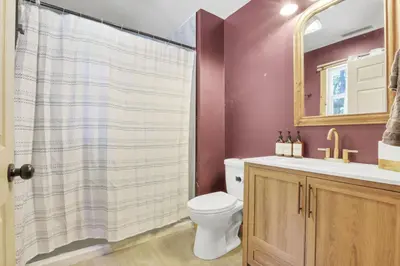 a bathroom with a toilet and a sink and a mirror at The Maple Cabin in Lancaster