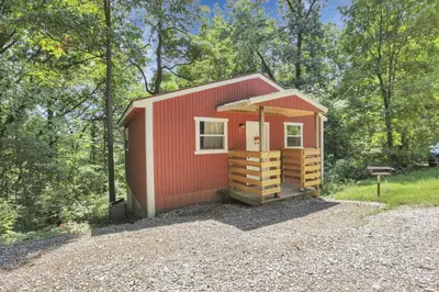 a red tiny house in the woods at The Maple Cabin in Lancaster