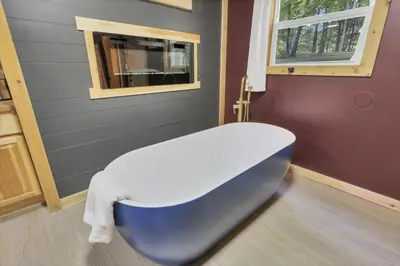 a bathroom with a blue and white bath tub at The Maple Cabin in Lancaster
