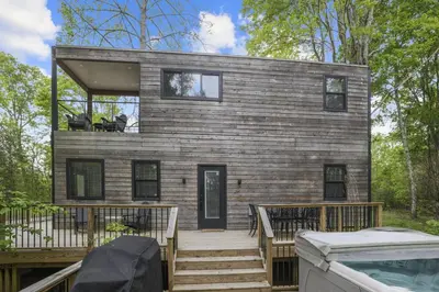a tiny house with a deck and a swimming pool at Hiltop Haven The Double Stack in Logan
