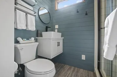 a bathroom with a white toilet and a mirror at Hiltop Haven The Double Stack in Logan