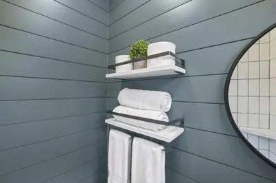 a blue bathroom with towels and a mirror at Hiltop Haven The Double Stack in Logan