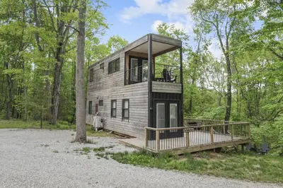 a tree house in the woods with a balcony at Hiltop Haven The Double Stack in Logan