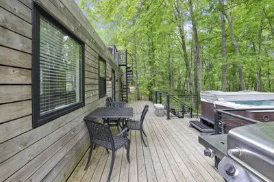 a wooden deck with a table and chairs and a grill at Hiltop Haven The Top Deck in Logan