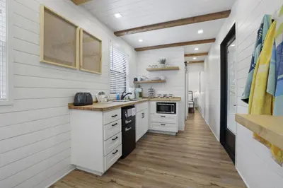a kitchen with white walls and wooden floors at Hiltop Haven The Top Deck in Logan
