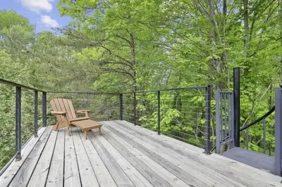 a wooden deck with a chair on top of it at Hiltop Haven The Top Deck in Logan