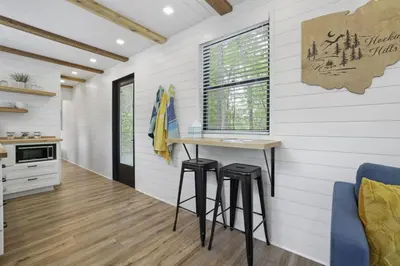 a kitchen with a table and stools in a room at Hiltop Haven The Top Deck in Logan