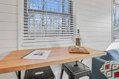 a table with a bottle of wine and two glasses at Hiltop Haven The Top Deck in Logan