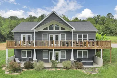 a house with a large deck on top of it at Serenity on Siverly by Purple Munky Hospitality in McArthur