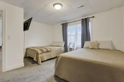 a bedroom with two beds and a window at Serenity on Siverly by Purple Munky Hospitality in McArthur