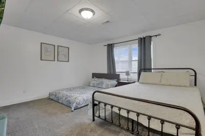 a bedroom with a bed and a couch and a window at Serenity on Siverly by Purple Munky Hospitality in McArthur