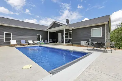 a swimming pool in front of a house at Serenity on Siverly by Purple Munky Hospitality in McArthur