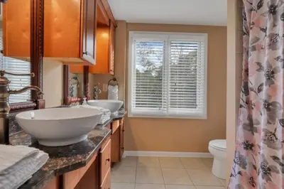 a bathroom with two sinks and a toilet and a window at Valley View Villa in Lancaster