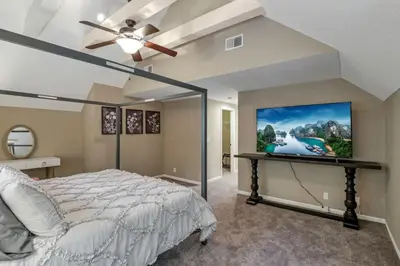 a bedroom with a bed and a flat screen tv at Valley View Villa in Lancaster