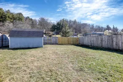 a backyard with a wooden fence and a yard at Nostalgic in Nelsonville in Nelsonville