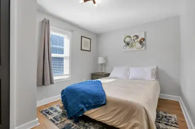 a bedroom with a bed with a blue blanket on it at Nostalgic in Nelsonville in Nelsonville
