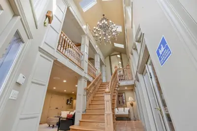 a staircase in a house with a chandelier at Daisy Glen Retreat - Amazing Indoor Pool in South Bloomingville