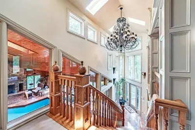 a staircase in a home with a chandelier at Daisy Glen Retreat - Amazing Indoor Pool in South Bloomingville