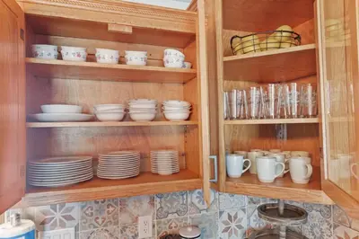 a cabinet filled with plates and cups and dishes at Cattle Cottage