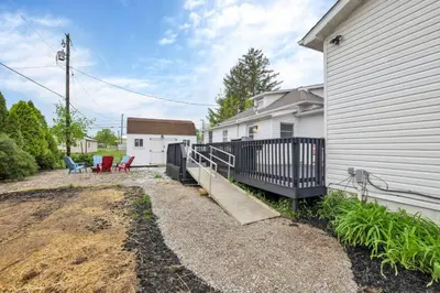 a house with a porch next to a building at Cattle Cottage