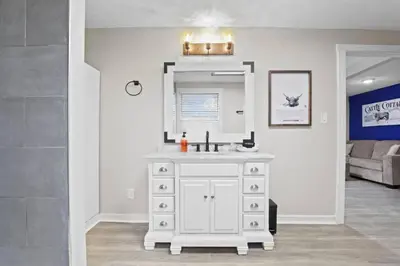 a bathroom with a white sink and a mirror at Cattle Cottage