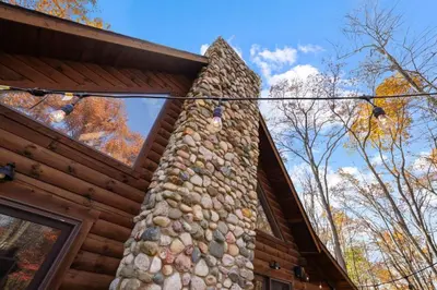 a log cabin with a rock wall on the side of it at Hike Away Hills in Logan