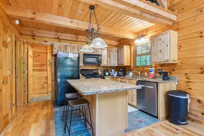 a kitchen with a large island in a wooden cabin at Hike Away Hills in Logan