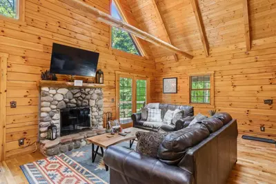 a living room with a leather couch and a fireplace at Hike Away Hills in Logan