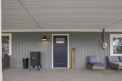 a front porch with a blue door and a couch at The Landing Spot in Pataskala