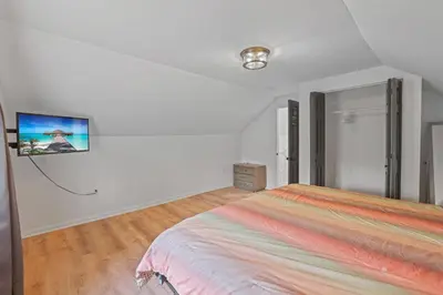 a bedroom with a bed and a tv on the wall at The Landing Spot in Pataskala