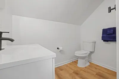 a white bathroom with a toilet and a sink at The Landing Spot in Pataskala