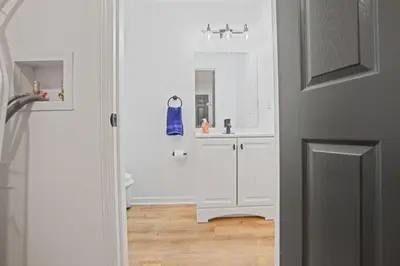 a white bathroom with a sink and a mirror at The Landing Spot in Pataskala