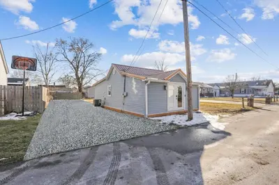 a house on a gravel driveway with a basketball hoop at The Shack in Buckeye Lake