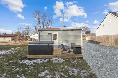 a tiny house with a deck with a hot tub at The Shack in Buckeye Lake