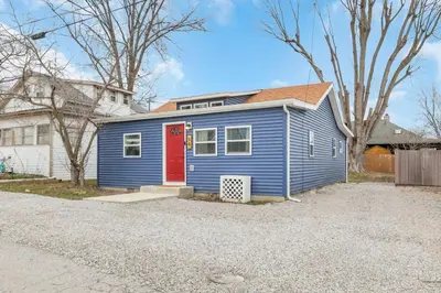 a blue house with a red door in a driveway at Gone Fishin in Buckeye Lake