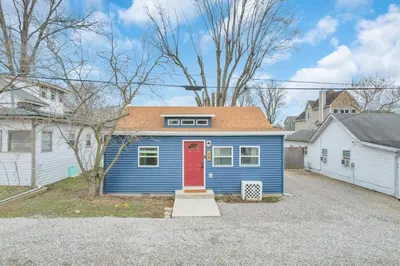 a blue house with a red door in a driveway at Gone Fishin in Buckeye Lake