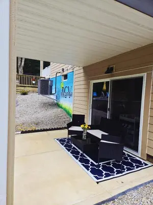 a patio with a table and chairs on a porch at The Backwoods Paradise in Logan